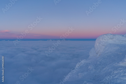Fototapeta Naklejka Na Ścianę i Meble -  Beautiful sunset above clouds in snow covered Low Tatras mountains during susnet in winter