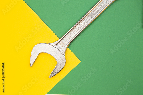 Home, House redecorating concept. A wrench on green and yellow background with copy space, top view, flat lay © 976photo