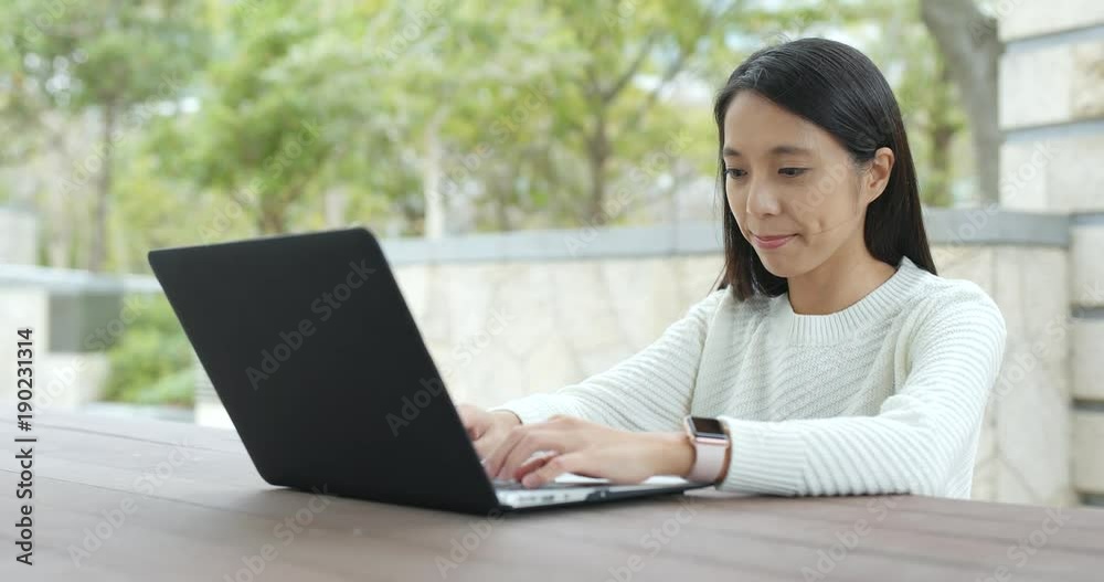 Woman working on notebook computer at outdoor coffee shop Woman working on notebook computer at outdoor coffee shop