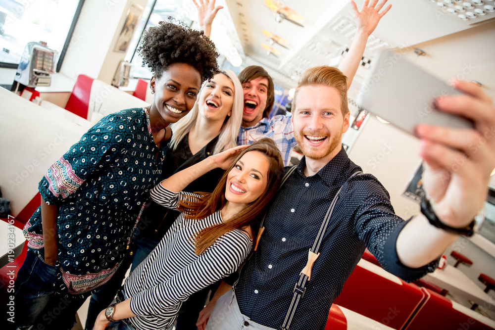 Obraz premium Group of young people taking selfie with mobile phone