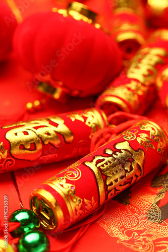 Chinese new year lanterns and fake firecrackers on red background that says good luck and happiness