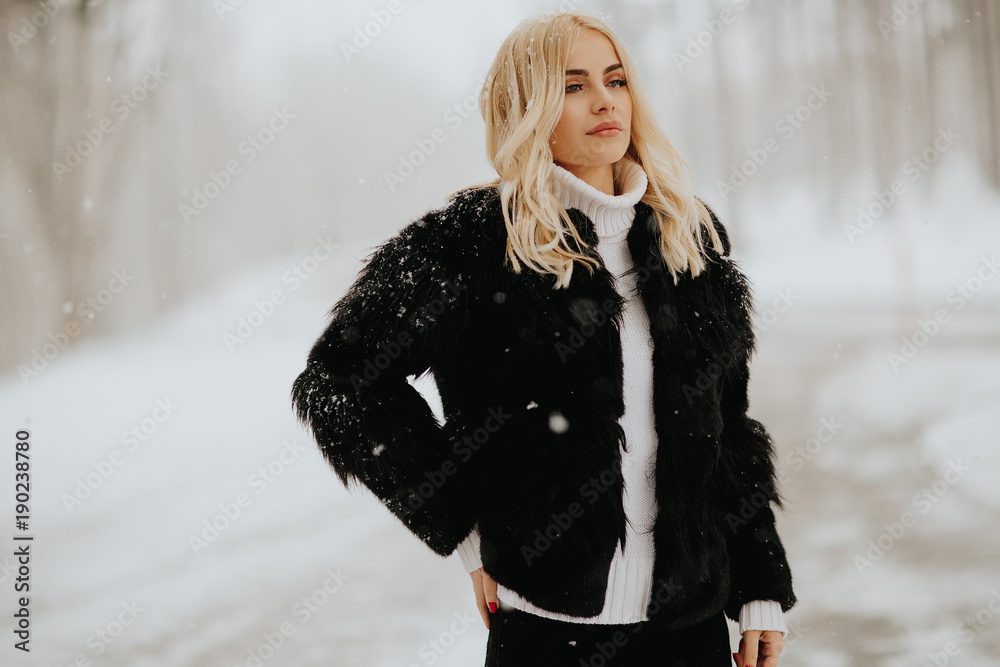 Blonde woman outside in snow winter coat Blonde woman outside in snow winter coat
