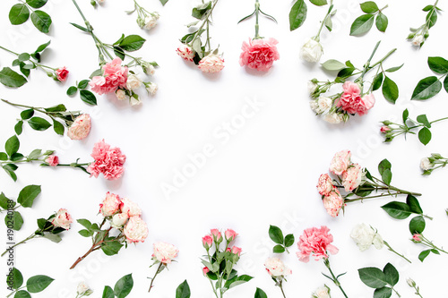 Round frame with pink buds of roses, branches and leaves isolated on white background. layout, top view