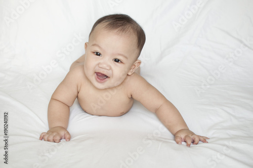 A nude portrait of a smiling baby boy indoor