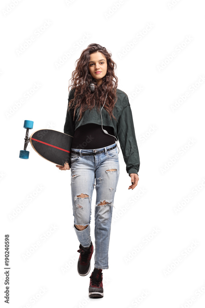 Teenage girl with a longboard walking towards the camera Teenage girl with a longboard walking towards the camera