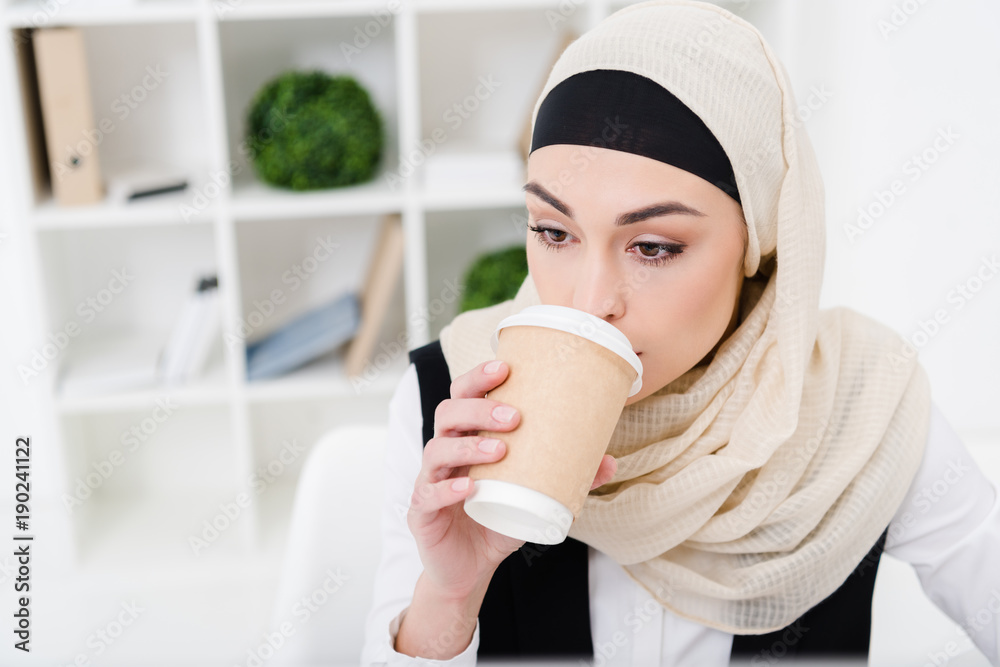 portrait of muslim businesswoman in hijab drinking coffee in office portrait of muslim businesswoman in hijab drinking coffee in office