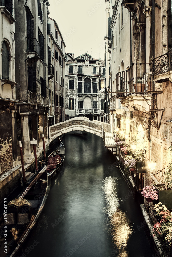 A restaurant lit up at night along a Venice canal.