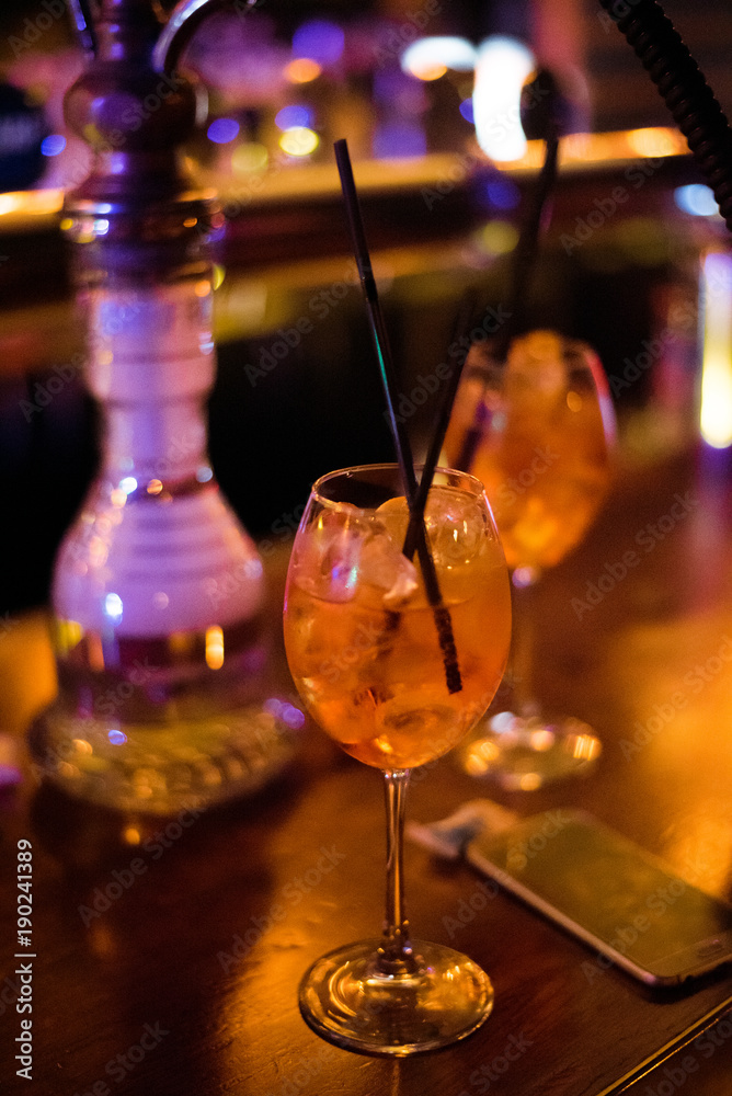 Alcohol bar, cocktail glass on bar counter, cocktail glass in a bar, Drinking cocktail in bar, cocktail in the glass with straws, Fresh drink coctail on a color background
