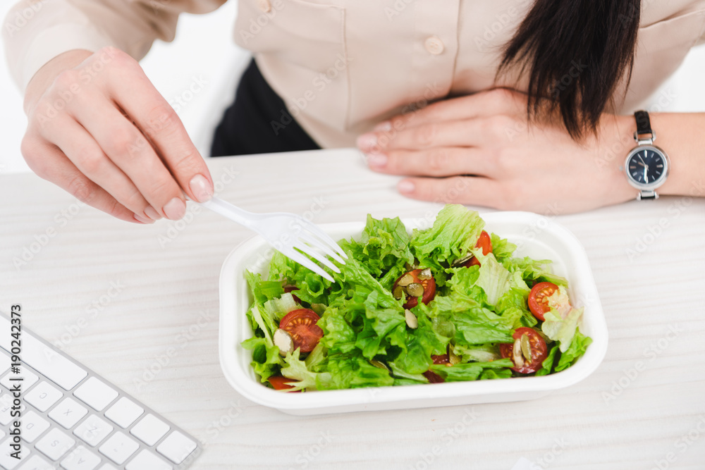 overhead view of businesswoman with take away food at workplace in office overhead view of businesswoman with take away food at workplace in office