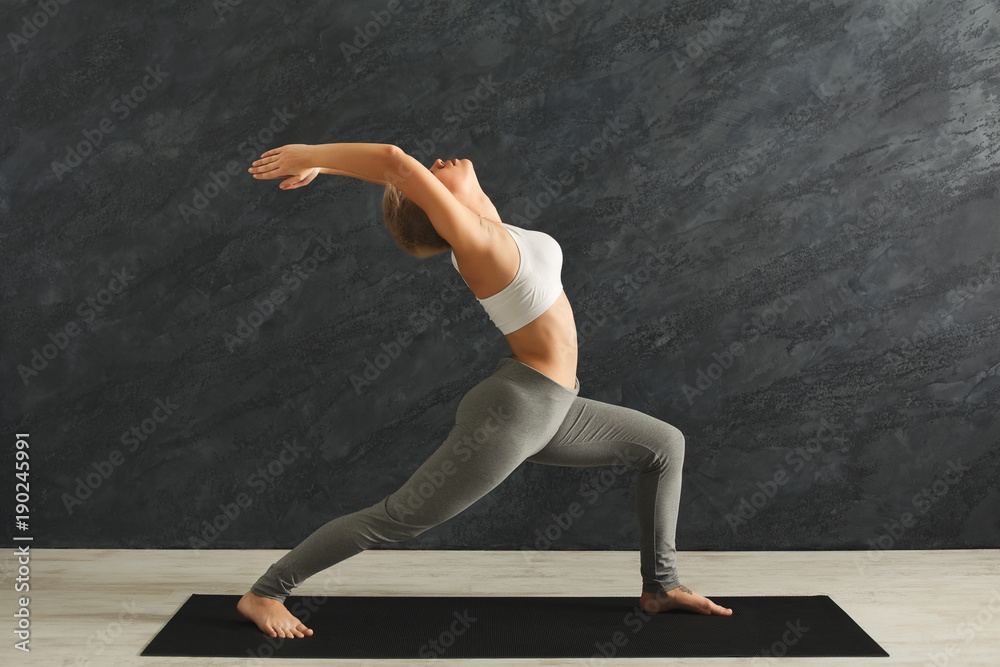 Woman training yoga in hero pose in gym