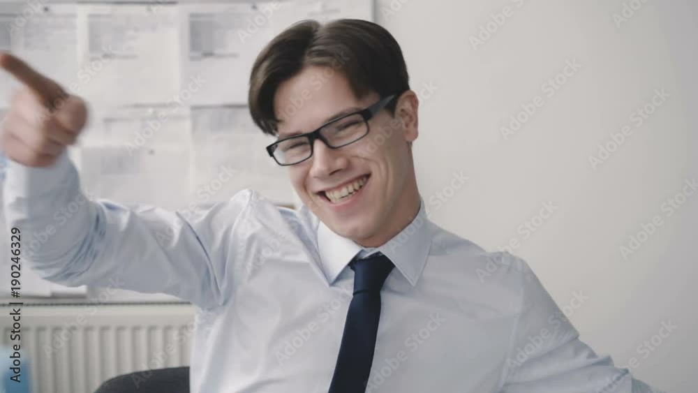 Happy funny businessman shows a thumb at camera in office. 4K Happy funny businessman shows a thumb at camera in office. 4K