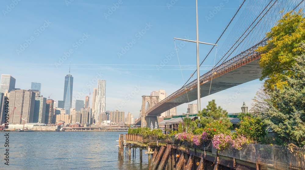NEW YORK CITY - OCTOBER 25, 2015: Downtown Manhattan from Brooklyn Bridge Park. The city attracts 50 million people every year NEW YORK CITY - OCTOBER 25, 2015: Downtown Manhattan from Brooklyn Bridge Park. The city attracts 50 million people every year