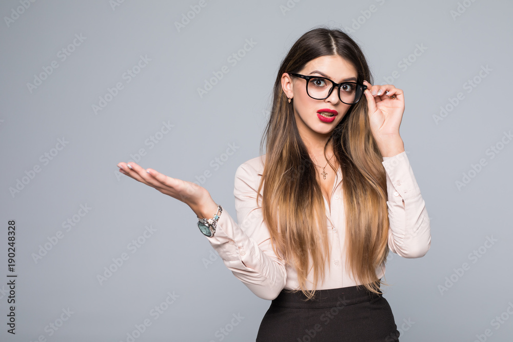 Smiling business woman present invisible product isolated over gray background Smiling business woman present invisible product isolated over gray background