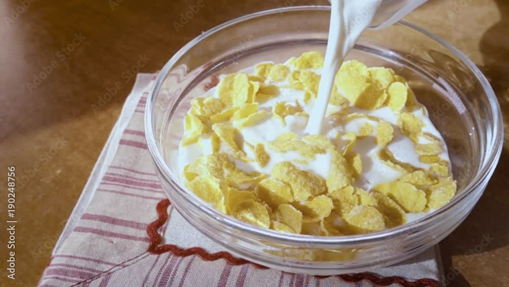 Crispy yellow corn flakes into the bowl for the morning a delicious Breakfast with milk. Slow motion with rotation tracking shot. Crispy yellow corn flakes into the bowl for the morning a delicious Breakfast with milk. Slow motion with rotation tracking shot.