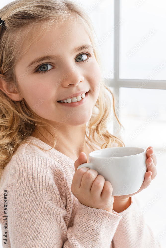 close-up portrait of happy little child drinking tea and looking at camera close-up portrait of happy little child drinking tea and looking at camera