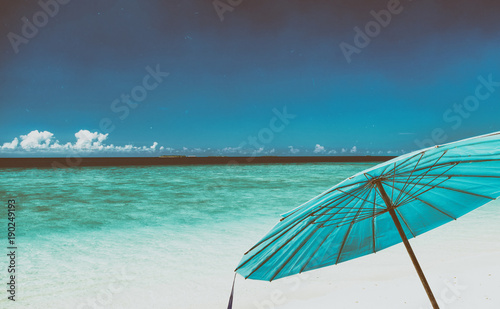Blue umbrella on a beautiful tropical beach. Holiday concept