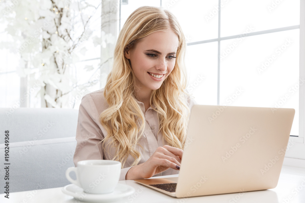 attractive young woman working with laptop in cafe attractive young woman working with laptop in cafe