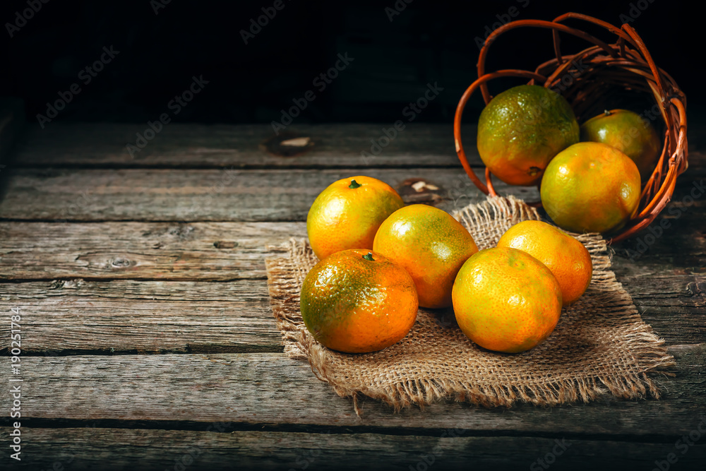 Tangerines (mandarins, clementines, citrus fruits) with leaves over rustic wooden background with copy space Tangerines (mandarins, clementines, citrus fruits) with leaves over rustic wooden background with copy space
