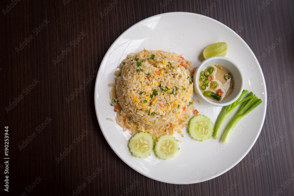 Crab meat fried rice with vegetables in dish on wooden table Crab meat fried rice with vegetables in dish on wooden table