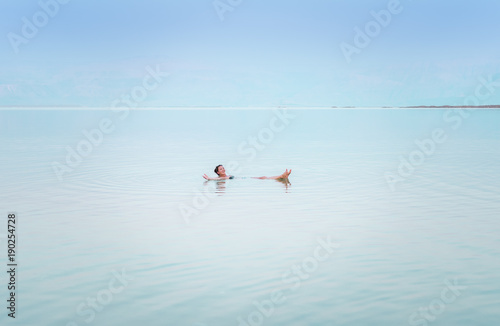 Girl relaxing in the water of Dead Sea.