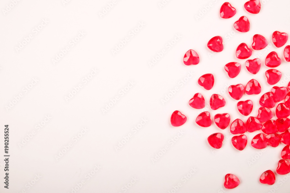 Red pink heart candies scattered around on white background. Lovers day greeting card gift.