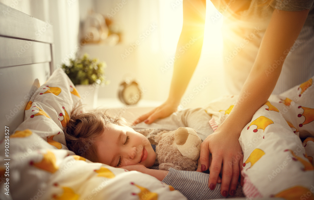 mother wakes up sleeping child daughter girl in morning. - obrazy, fototapety, plakaty 