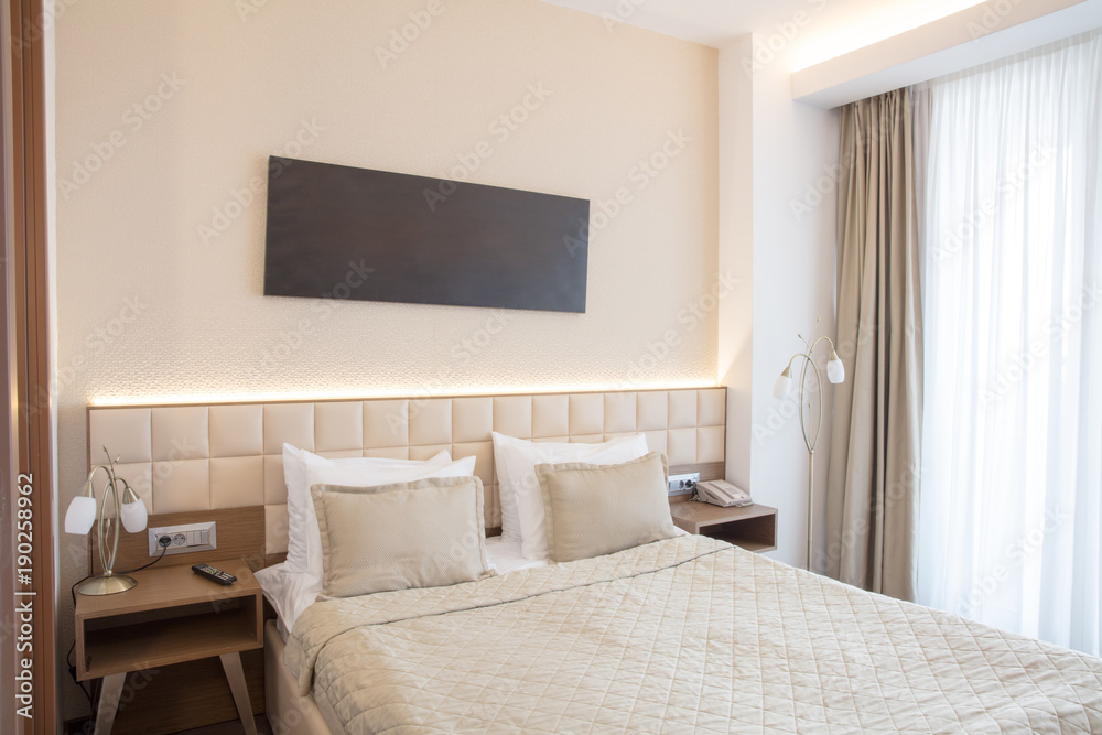 interior of bright bedroom with large bed and big window interior of bright bedroom with large bed and big window
