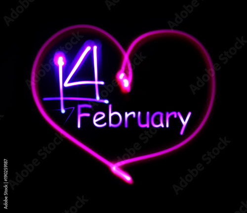pink luminous neon heart with an inscription on February 14 in the middle