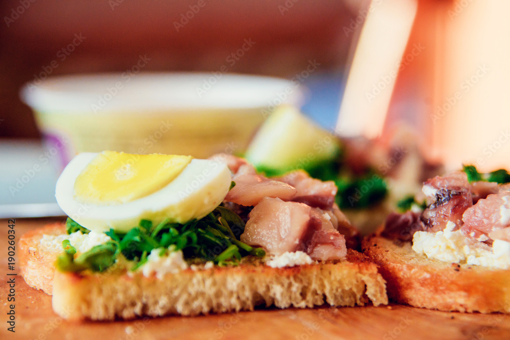 bruschetta, appetizer, canapes: fish tuna and spinach on toast of white bread, with egg on wooden Board bruschetta, appetizer, canapes: fish tuna and spinach on toast of white bread, with egg on wooden Board