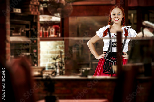 Young slim woman in bavarian clothes and her small business of bar 