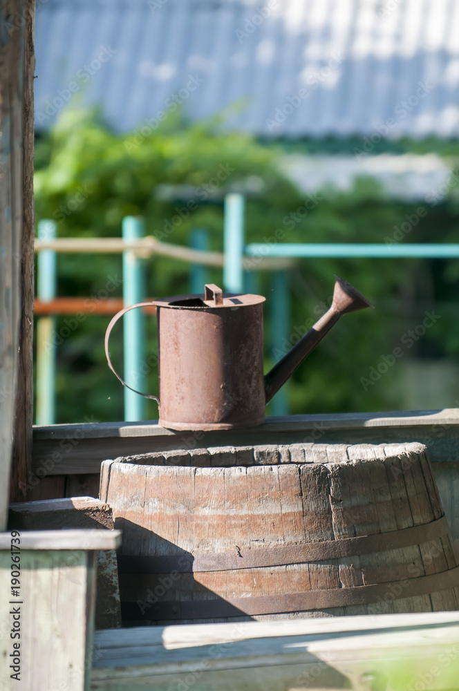 Wooden barrel and watering can