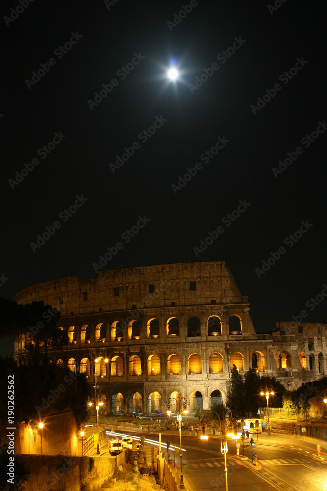 Summer. Italy. Rome. Night Colosseum with illumination. The moon in the sky