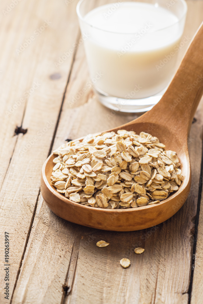 Oat flakes in wooden spoon with milk, blueberries for healthy breakfast, selective focus, Oat flakes in wooden spoon with milk, blueberries for healthy breakfast, selective focus,