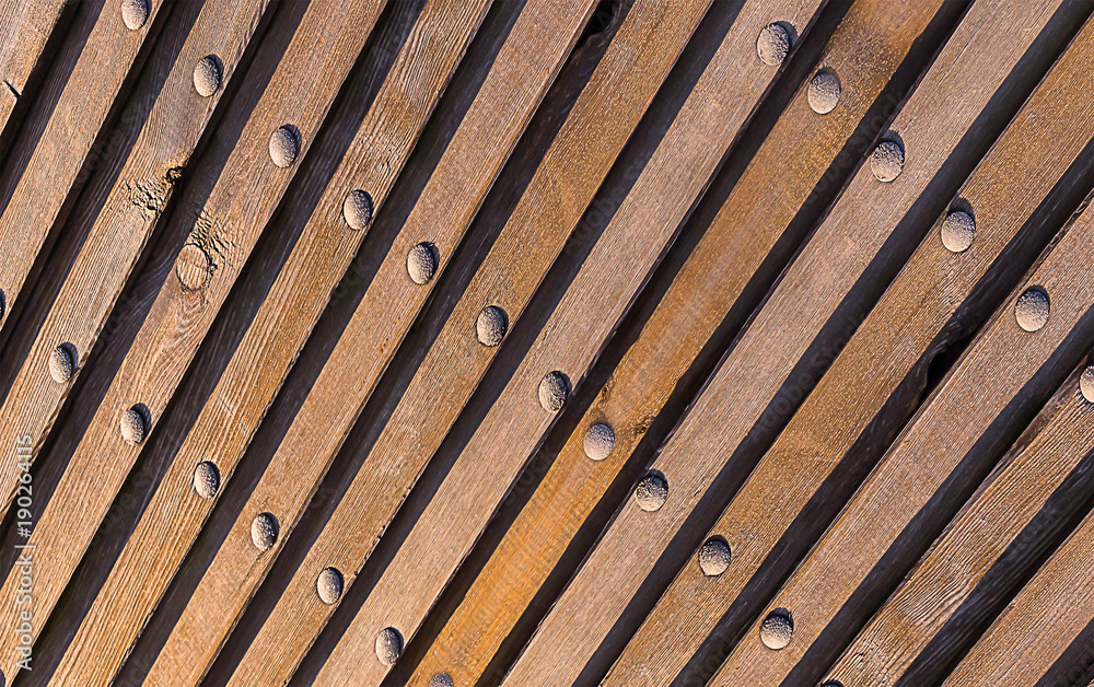 brown natural background. Wood texture inclined lines perspective perspective vertical metallic rivets industrial pattern