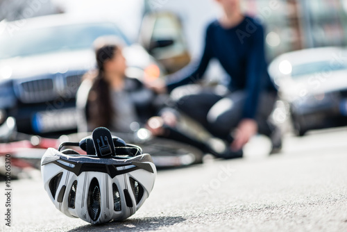 Close-up of a bicycling helmet fallen down on the ground after accidental collision between bicycle and a 4x4 car