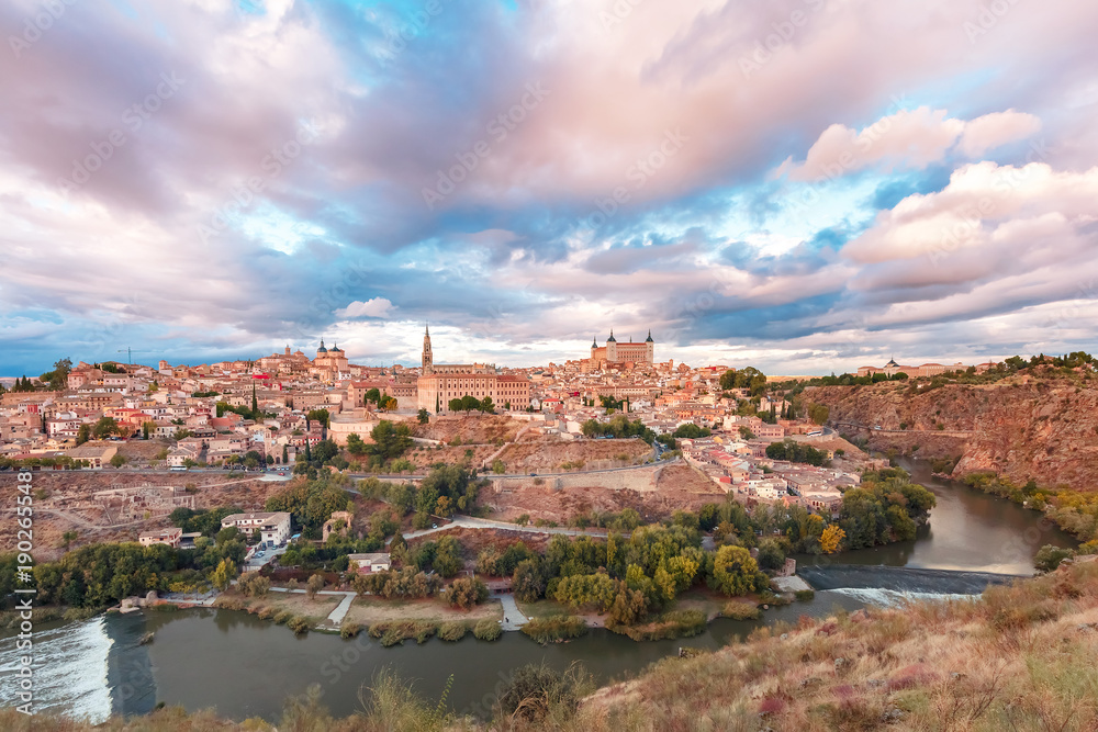 Panorama of Old city of Toledo with Cathedral, Alcazar and river Tajo at dusk, Castilla La Mancha, Spain
