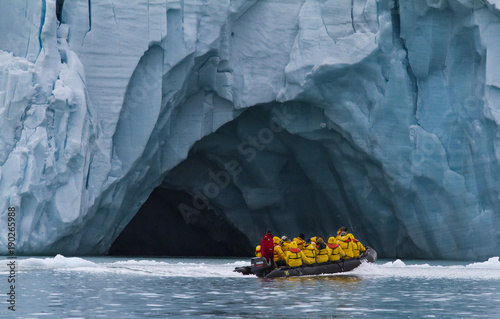 tourists traveling in a small zodiac boat in archipelago of  Svalbard photo