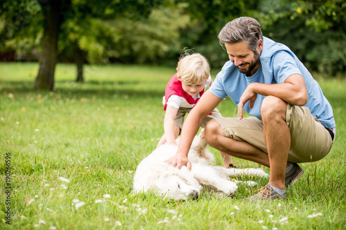 Vater und Sohn streicheln Hund