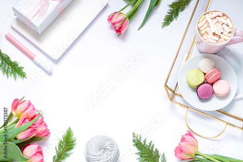 Flat lay composition with fresh flowers, tray, coffee and macaroons. Lifestyle concept frame. Top view. Copy space