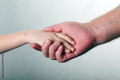 old man and kid holding hands together