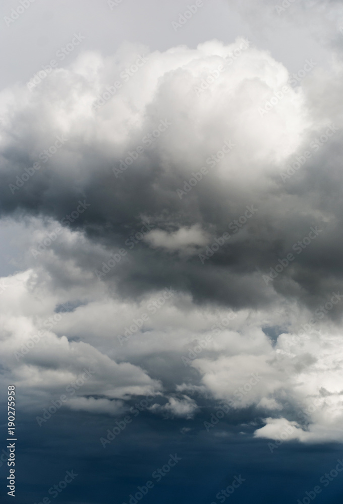 Obraz premium Gray and white storm clouds on a dark blue sky