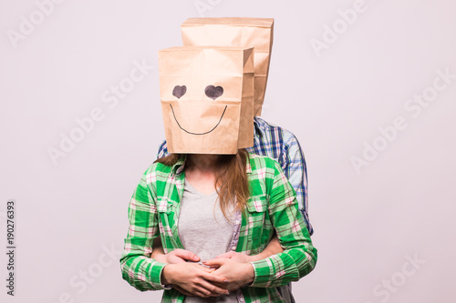 Valentine's day concept - Young love couple with bags over heads on white background