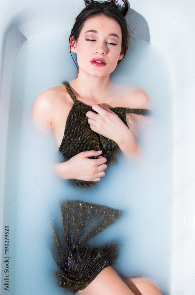 Beautiful young model girl in milk bath, relaxing, joy, rejuvenation, treatment, glamour concept Beautiful young model girl in milk bath, relaxing, joy, rejuvenation, treatment, glamour concept