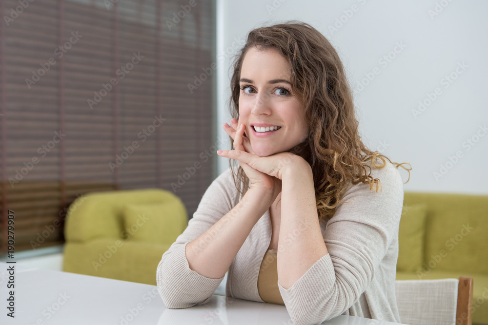 Smiling Attractive Woman at Table in Living Room Smiling Attractive Woman at Table in Living Room