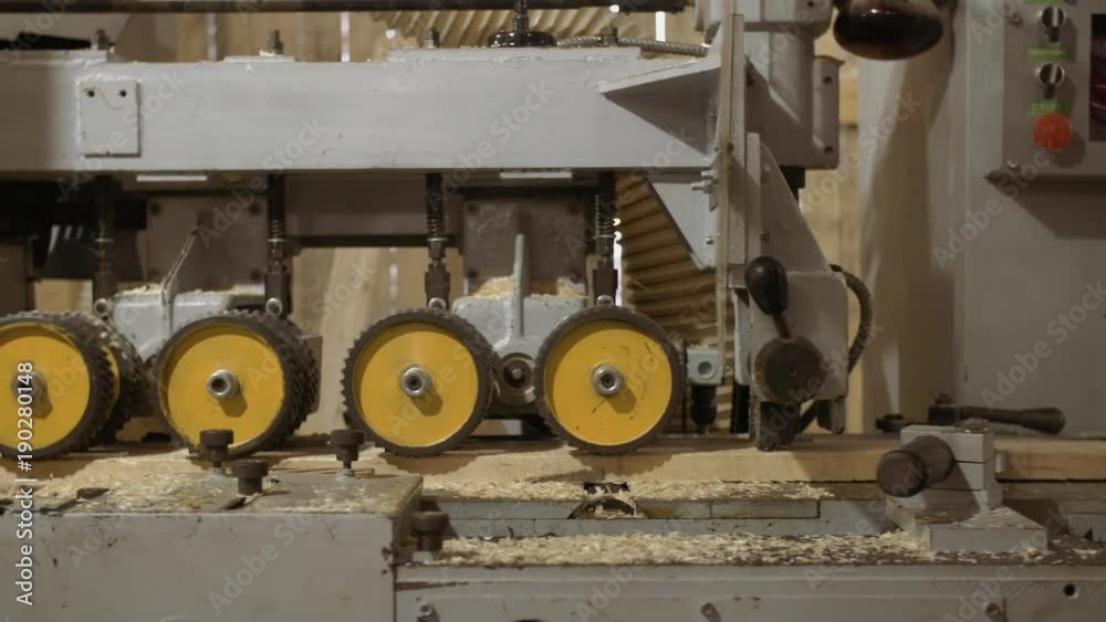 Running spiked wheels of lumber refiner machine working on wood at sawmill production, close up Running spiked wheels of lumber refiner machine working on wood at sawmill production, close up