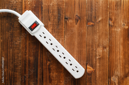 Electrical power strip on wood. Top down view. photo