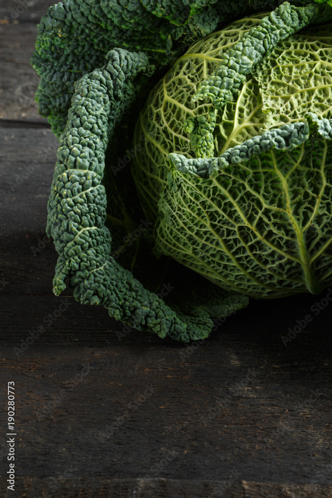 Savoy cabbage on a dark wooden table
