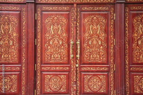 Old, massive, wooden doors with patterns and large door handles