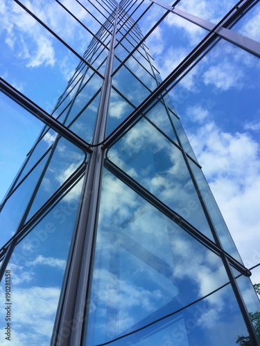 Glass building with reflection of clouds and sky