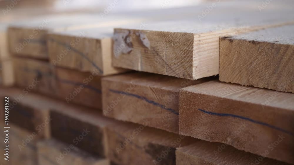 Stacks of processed  packed lumber plank stored in yard of woodwork facility on sunny winter day